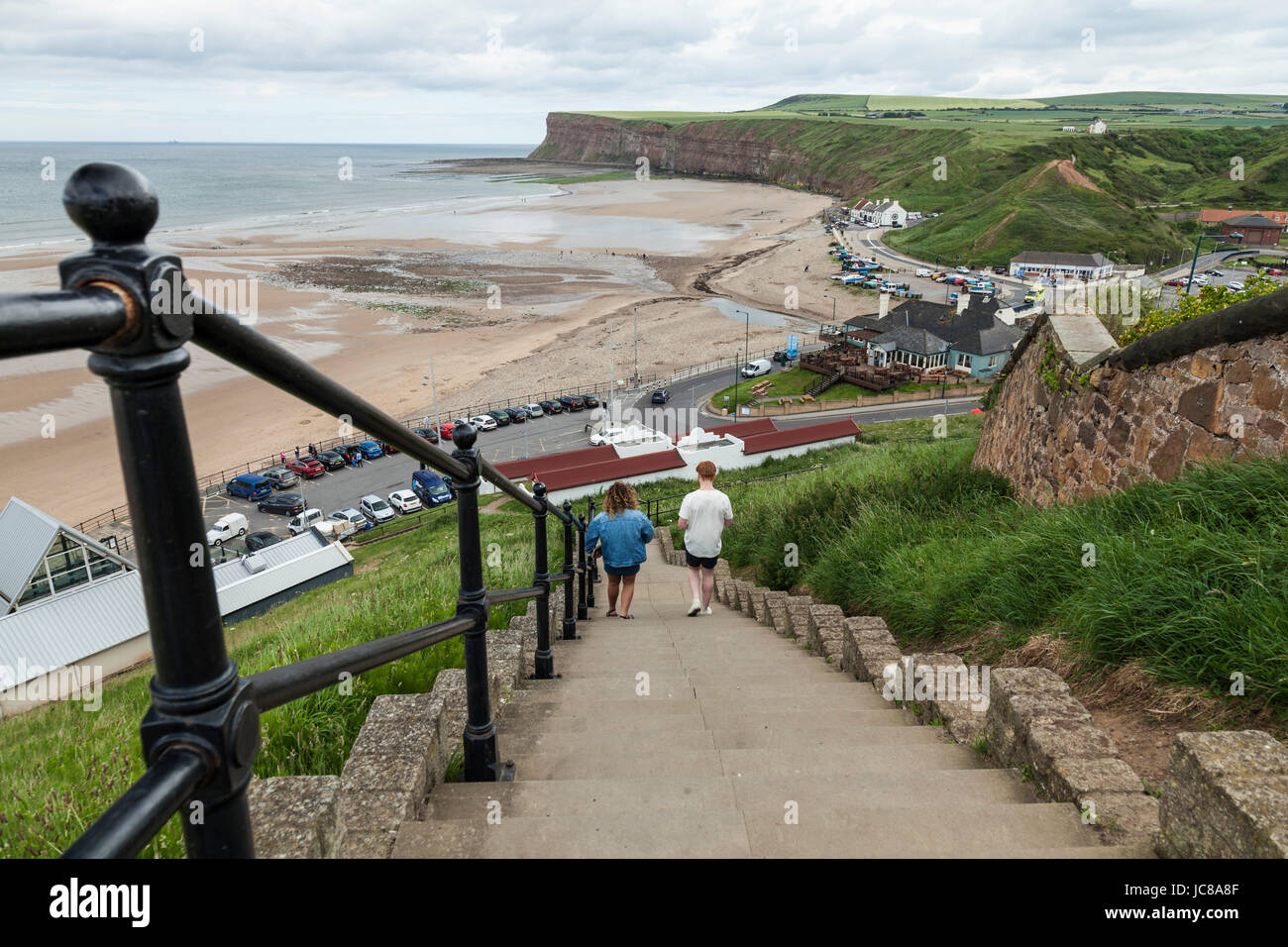 A man and woman walk down the steep steps to the beach area at Saltburn by the Sea, England, UK Stock Photo