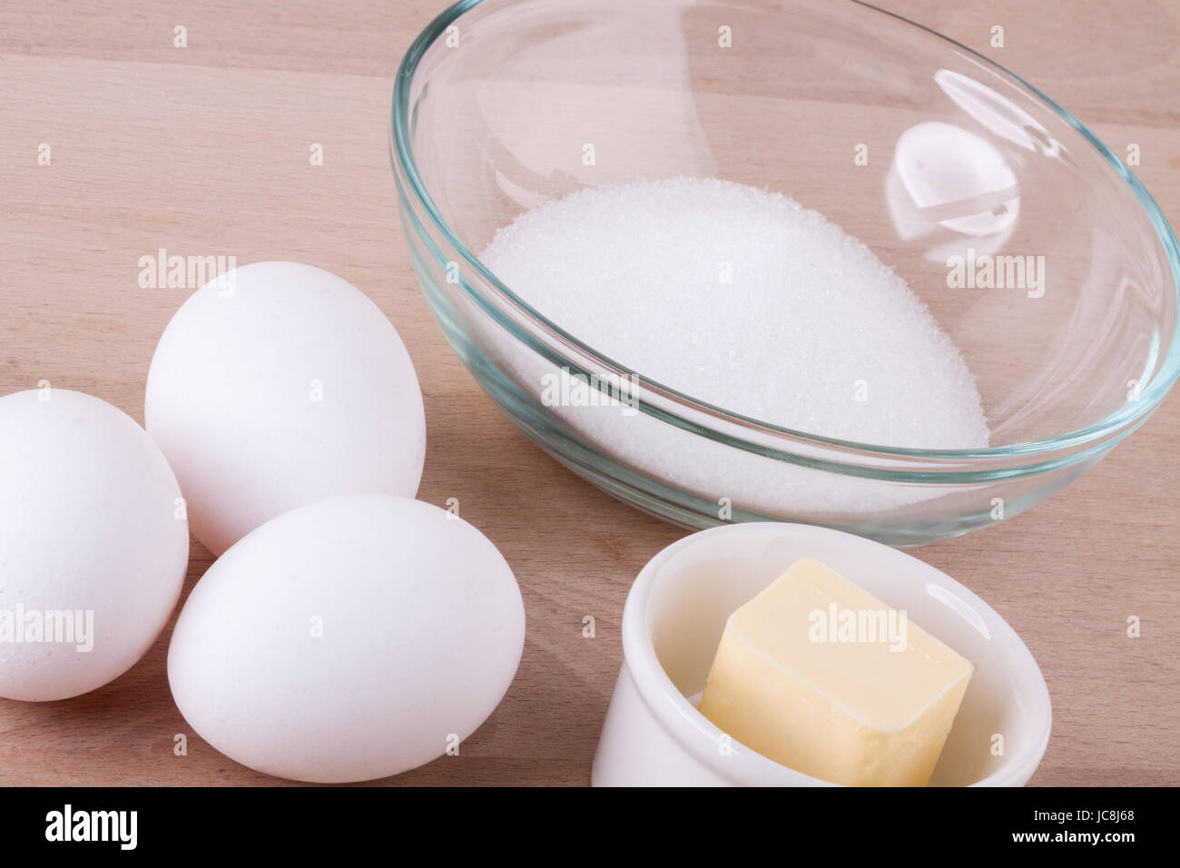 Backzutaten in der Küche mir Eiern, Mehl, Butter und Zucker um einen Teig zu rühren und einen Kuchen zu backen Stock Photo