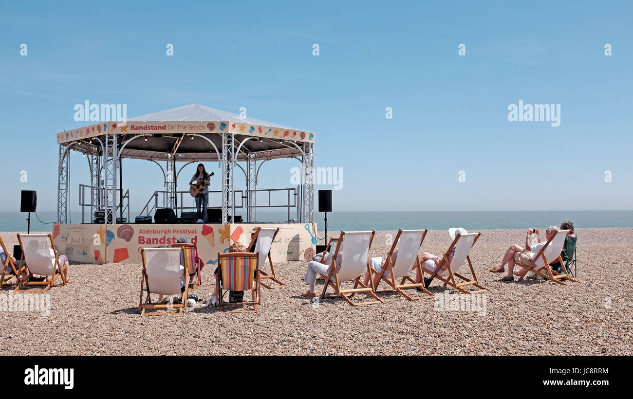 Aldeburgh Suffolk, UK. 14th June, 2017. Visitors enjoy the hot sunny weather and a concert in the bandstand on the beach along Aldeburgh seafront which is part of their annual music and arts festival . Hot sunny weather is forecast to spread across Britain again in the next few days with temperatures reaching as high as 28 degrees in some parts Credit: Simon Dack/Alamy Live News Stock Photo