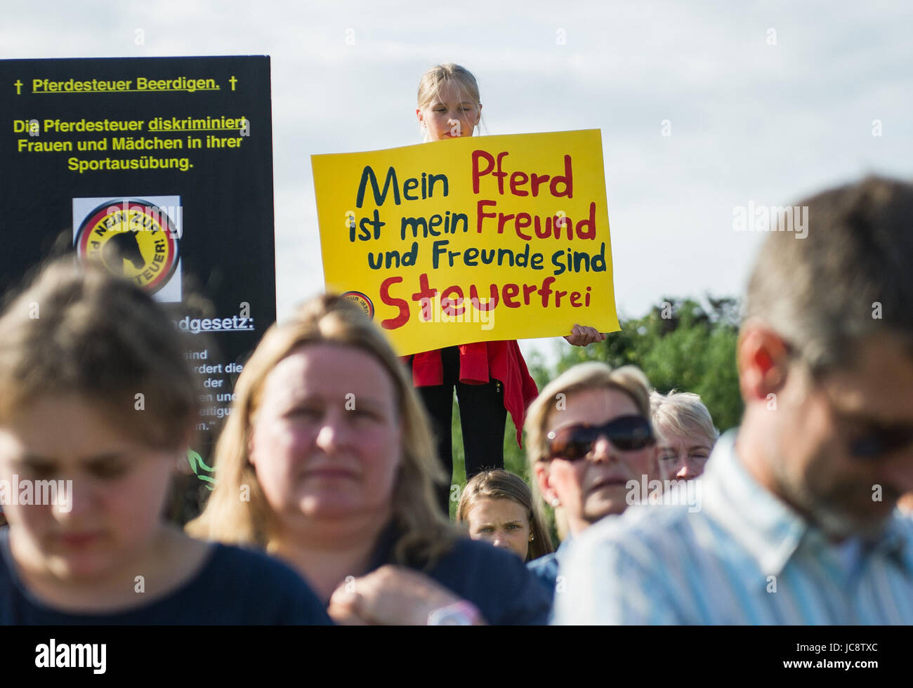 Tangstedt, Germany. 14th June, 2017. A child holds up a banner saying 'Mein Pferd ist mein Freund und Freunde sind steuerfrei' (lit. my horse is my friend and friends are tax free) during protests against the intended introduction of a horse tax before the local council's session in Tangstedt, Germany, 14 June 2017. Last November the introduction of the tax could be stopped last-minute. Photo: Christina Sabrowsky/dpa/Alamy Live News Stock Photo