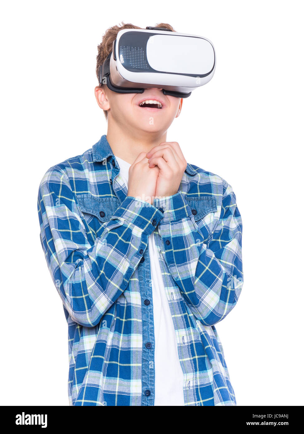 Amazed teen boy screaming, wearing virtual reality goggles watching movies or playing video games. Surprised teenager looking in VR glasses. Child exp Stock Photo