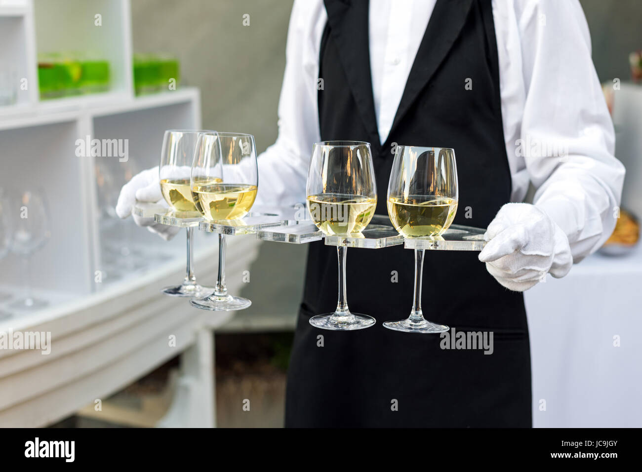 Midsection of professional waiter in uniform serving wine during buffet