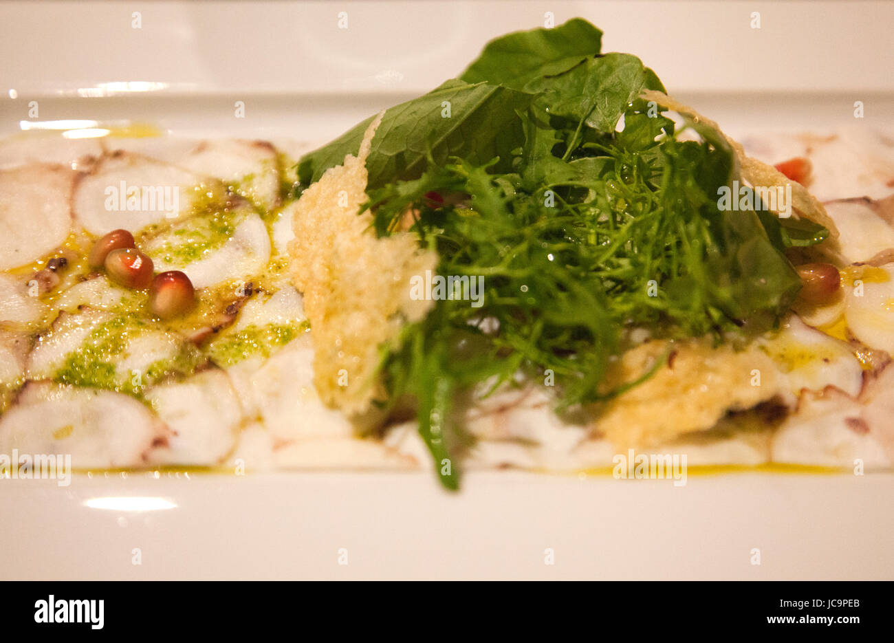Dish of Octopus Carpaccio with pomegranate and Rocket  at DOP Restaurant in Porto - Portugal Stock Photo