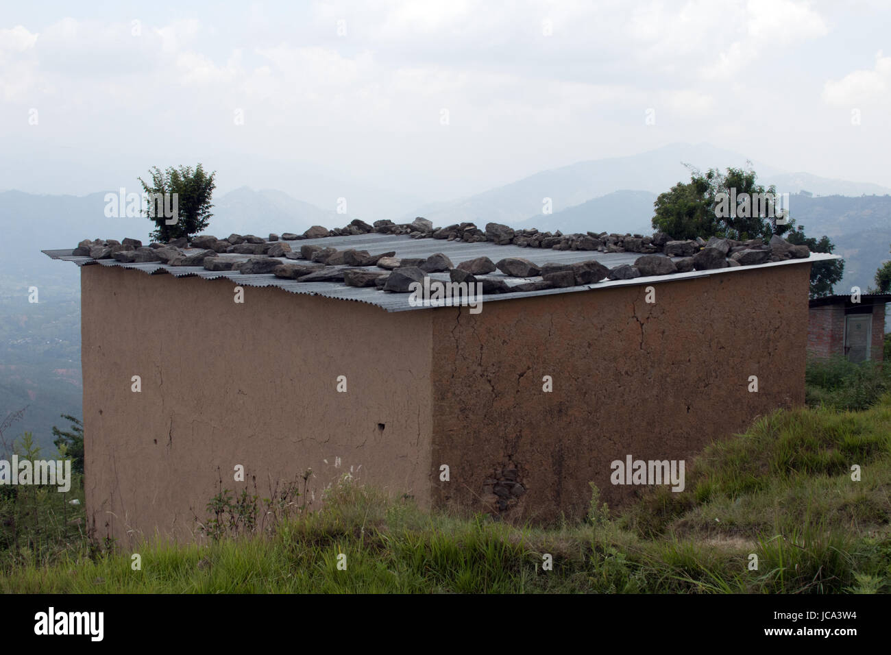 A single storey temporary shelter with a tin roof in Dhulikhel while waiting for earthquake rebuilding Nepal Stock Photo