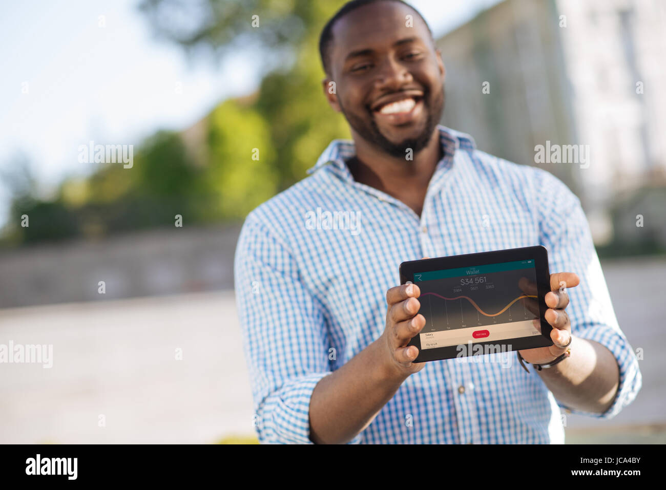 Creative analytical man showing a diagram on his gadget Stock Photo - Alamy