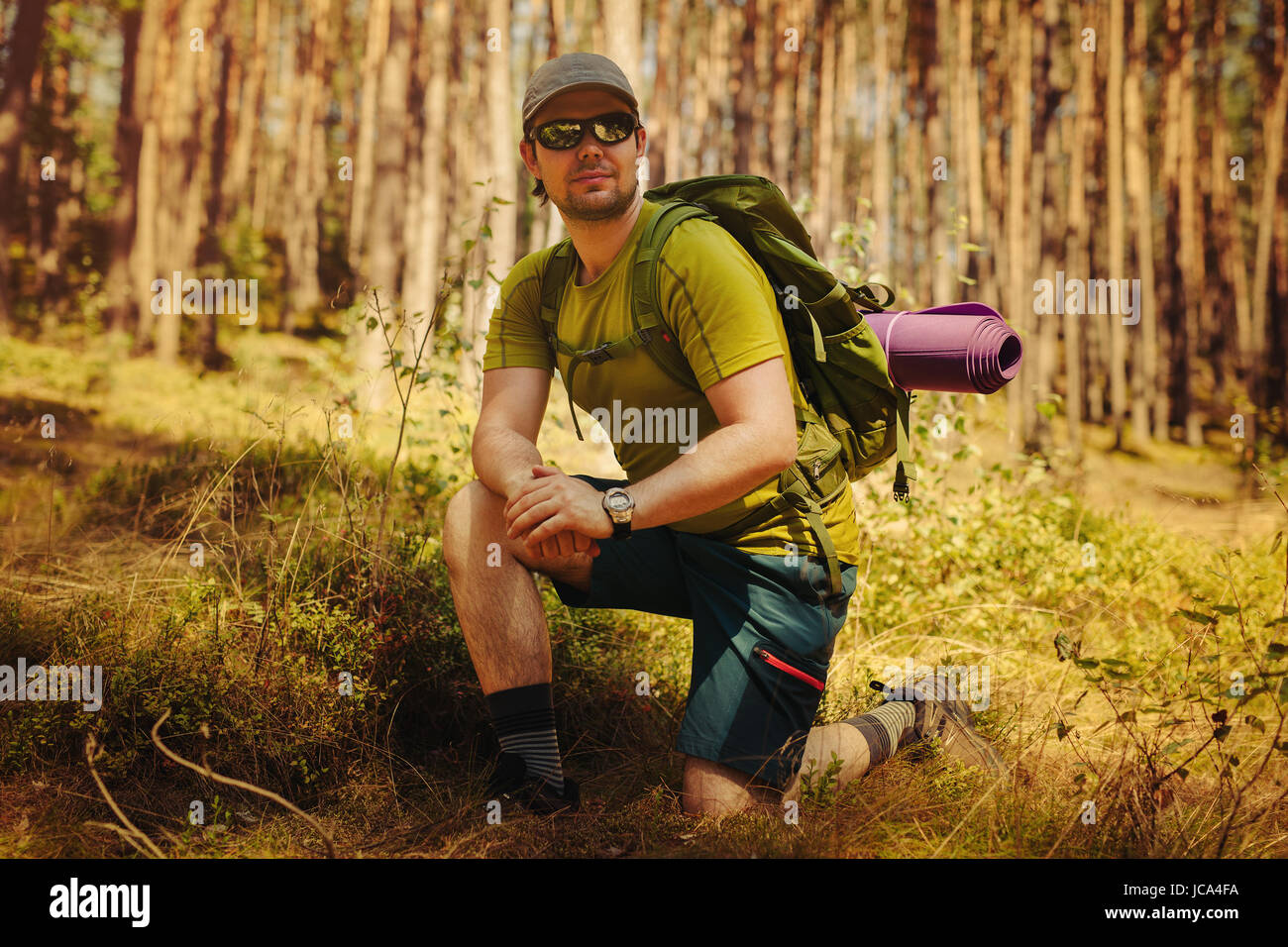 Young man tourist with sunglasses and backpack portrait in forest Stock Photo