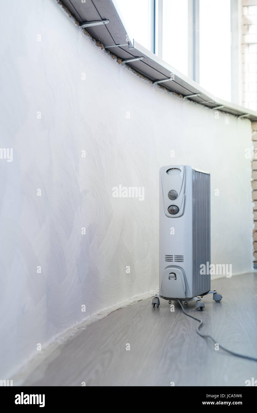 Electrical heater under windows in home with new interior Stock Photo