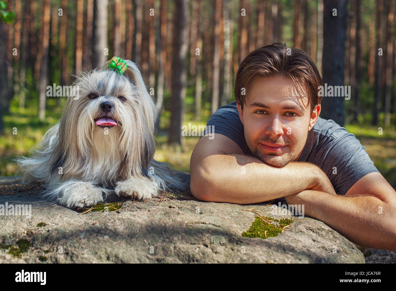 Young man with shih tzu dog portrait in forest Stock Photo