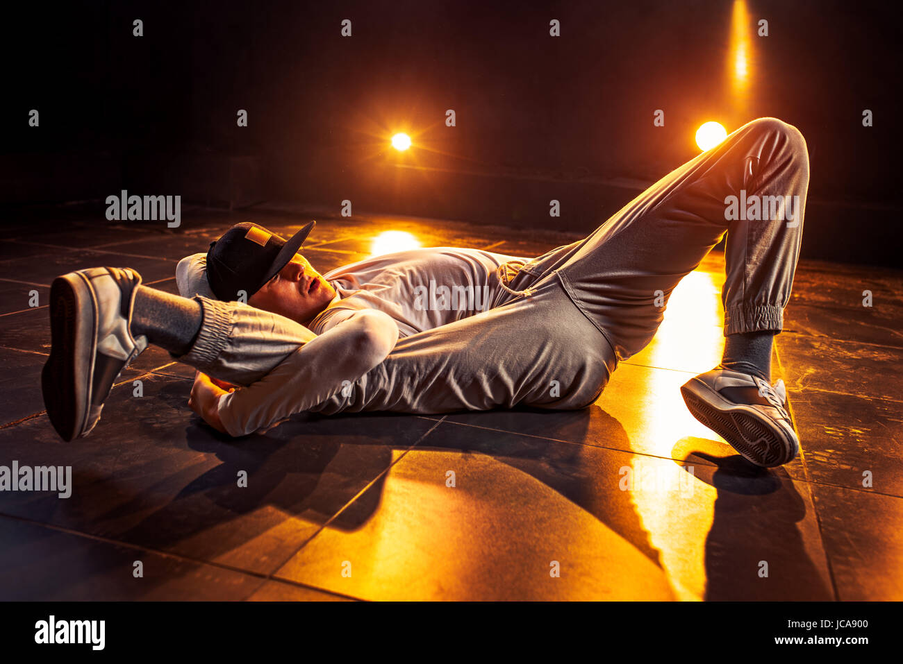 Young man break dancing in club with red lights. Vibrant contrast colors. Stock Photo