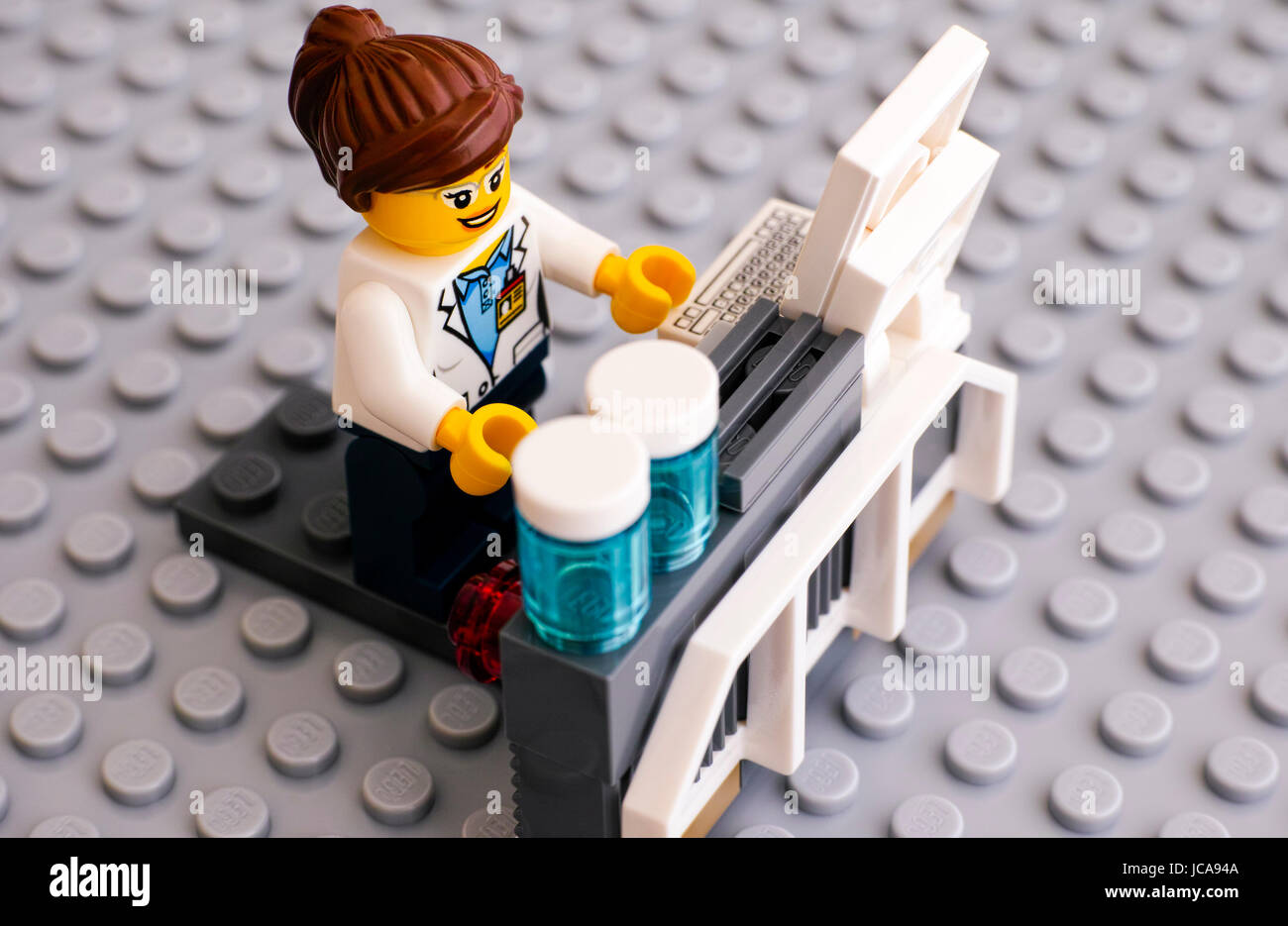 Tambov, Russian Federation - June 10, 2015 Lego scientist on her workplace on gray baseplate. Studio shot. Stock Photo