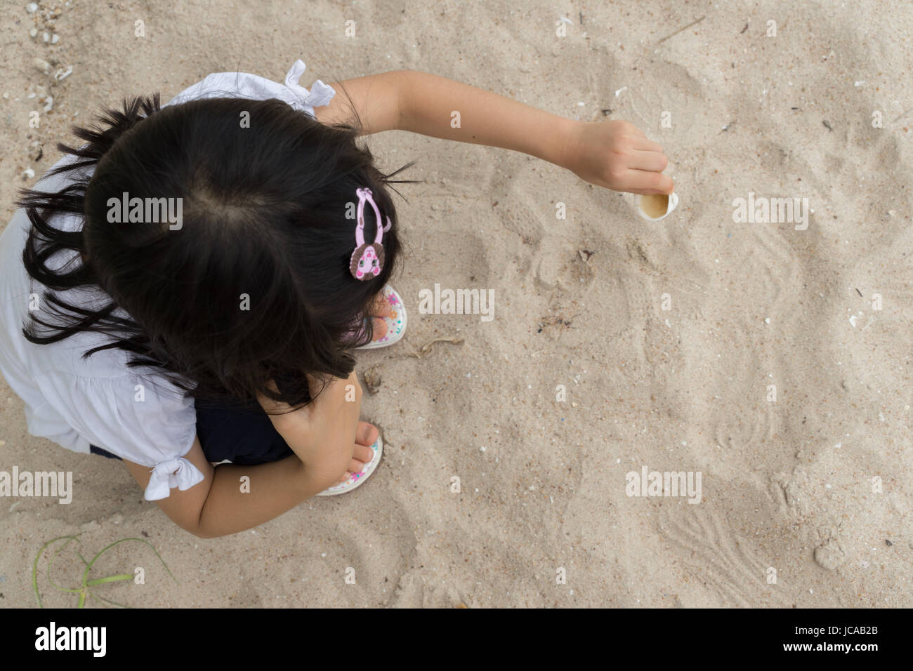 Asian girl playful cheer sand play enjoy Stock Photo