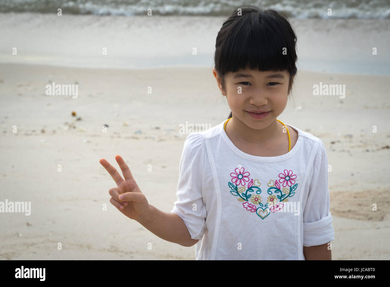 Asian girl playful cheer sand play enjoy Stock Photo