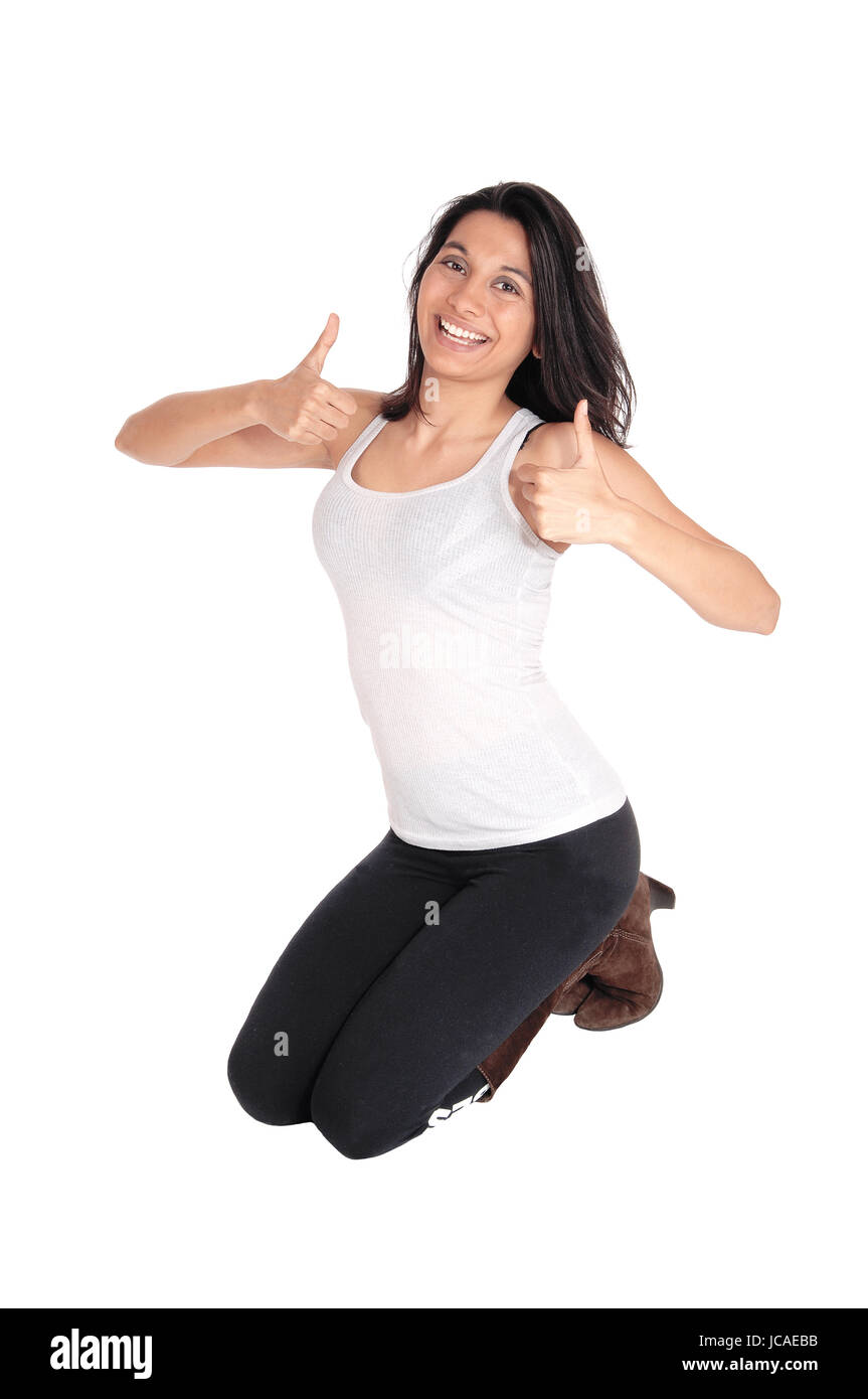 A lovely smiling Hispanic woman kneeling on the floor showing her thumps up, isolated for white background. Stock Photo
