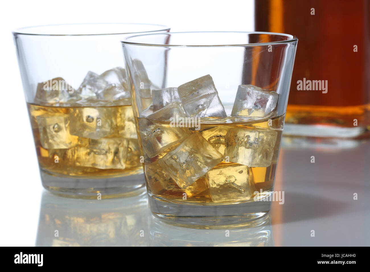 Whisky im Glas und in einer Flasche mit Eiswürfeln Stock Photo