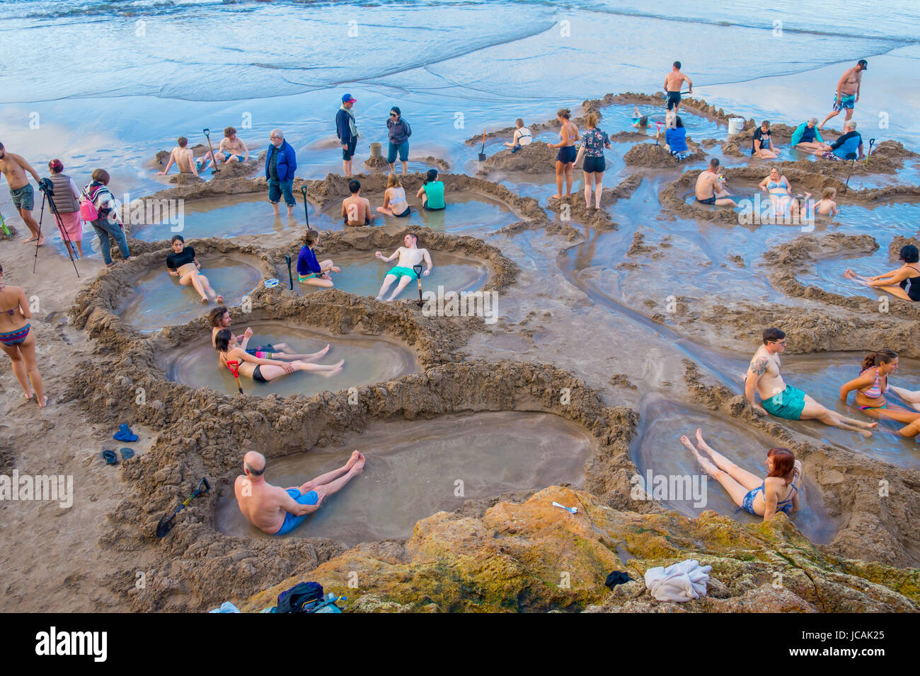 NORTH ISLAND, NEW ZEALAND- MAY 16, 2017: Visitors making small hot water pools in Hot Water beach.it one of the most popular geothermal attractions in Stock Photo