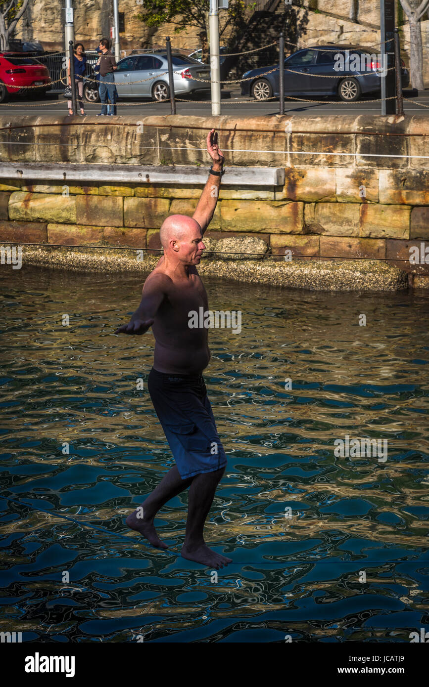 Man walking on rope in Walsh Bay, also called slacklining or slack rope