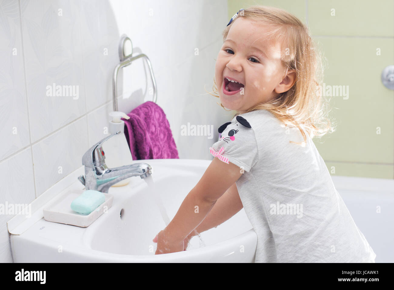 Little girl washing her hands in bathroom Stock Photo - Alamy