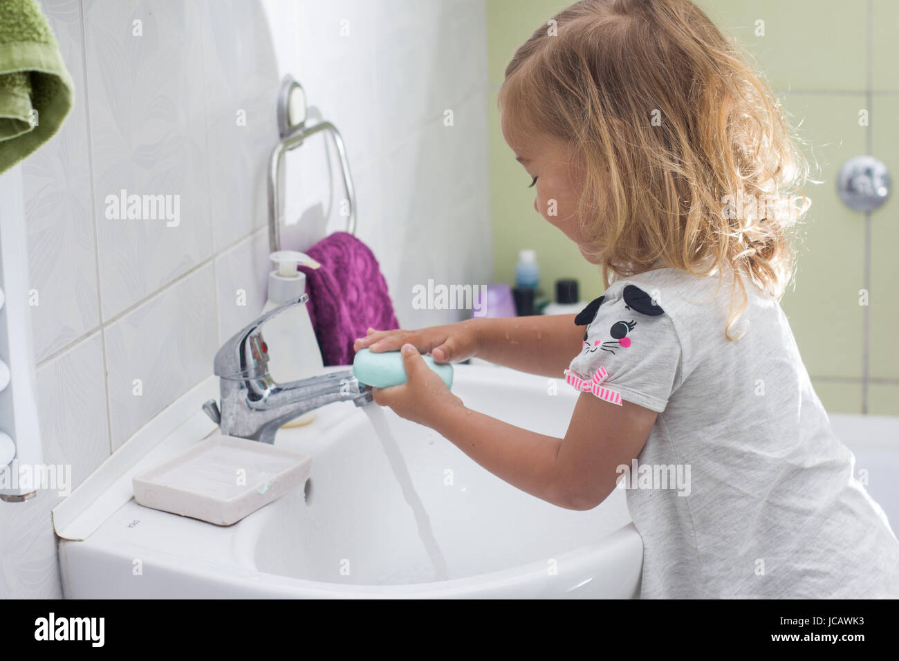 Little girl washing her hands in bathroom Stock Photo - Alamy