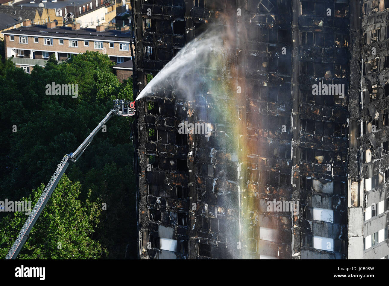 Firefighters spray water after a fire engulfed the 24-storey Grenfell Tower in west London. Stock Photo