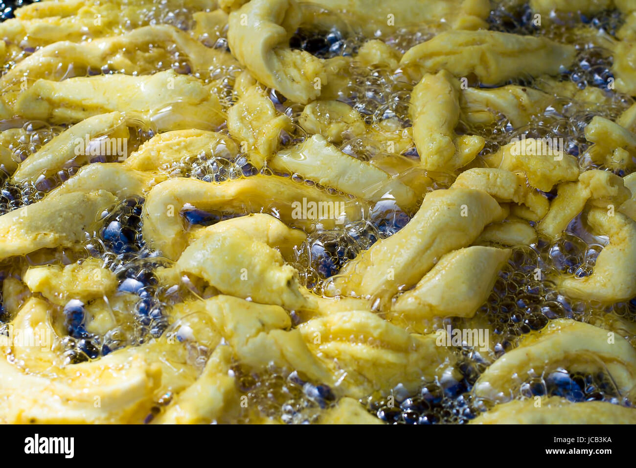 Indian snacks in the hot oil in the pan. Stock Photo
