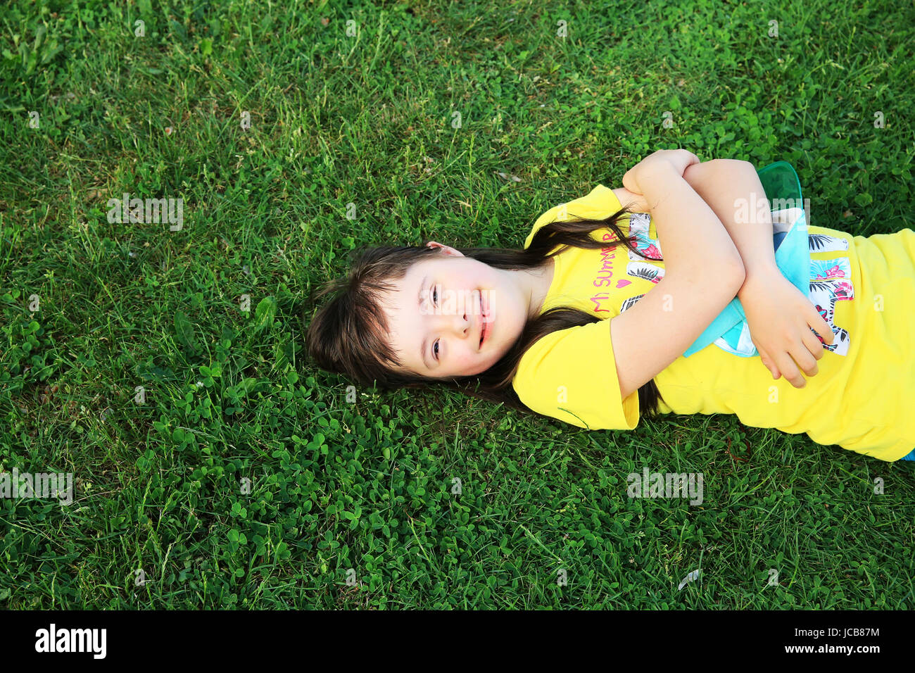 Young girl on the background of green grass Stock Photo - Alamy