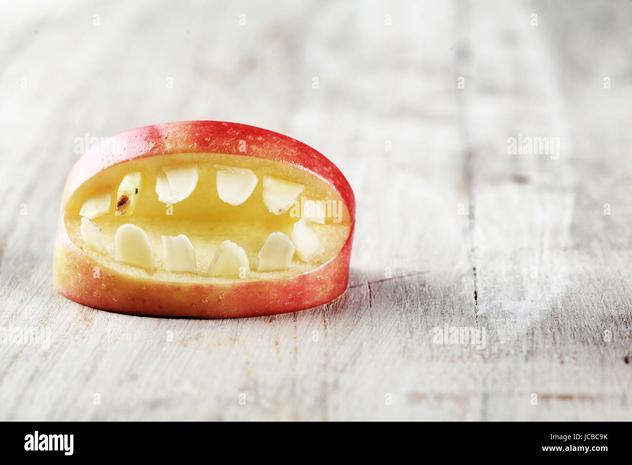Scary Halloween apple mouth with bared teeth on a textured white background with copyspace for your greeting or invitation Stock Photo