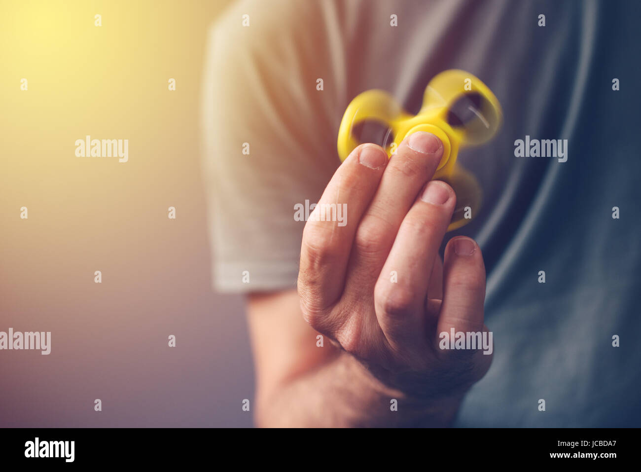 Adult man playing with fidget spinner toy, selective focus Stock Photo