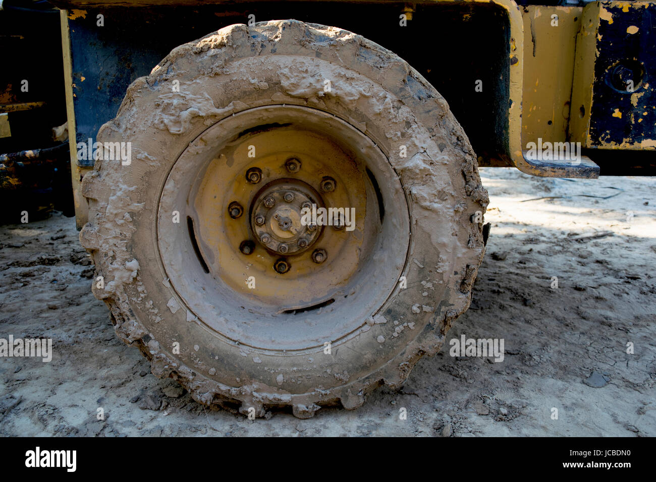 large tred muddy tire on construction vehicle Stock Photo