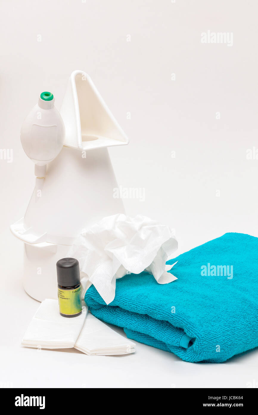 Inhalationsgerät mit Eukalyptusöl, Papiertaschentüchern und Handtuch vor weißem Hintergrund Stock Photo