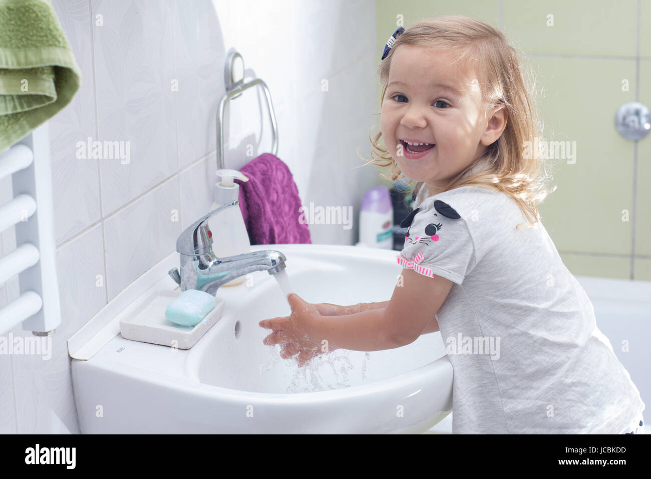 Little girl washing her hands in bathroom Stock Photo - Alamy