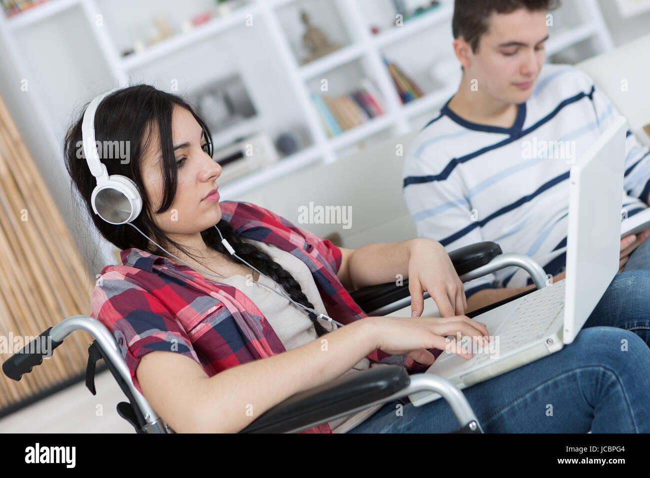 Adolescent in wheelchair using computer Stock Photo - Alamy