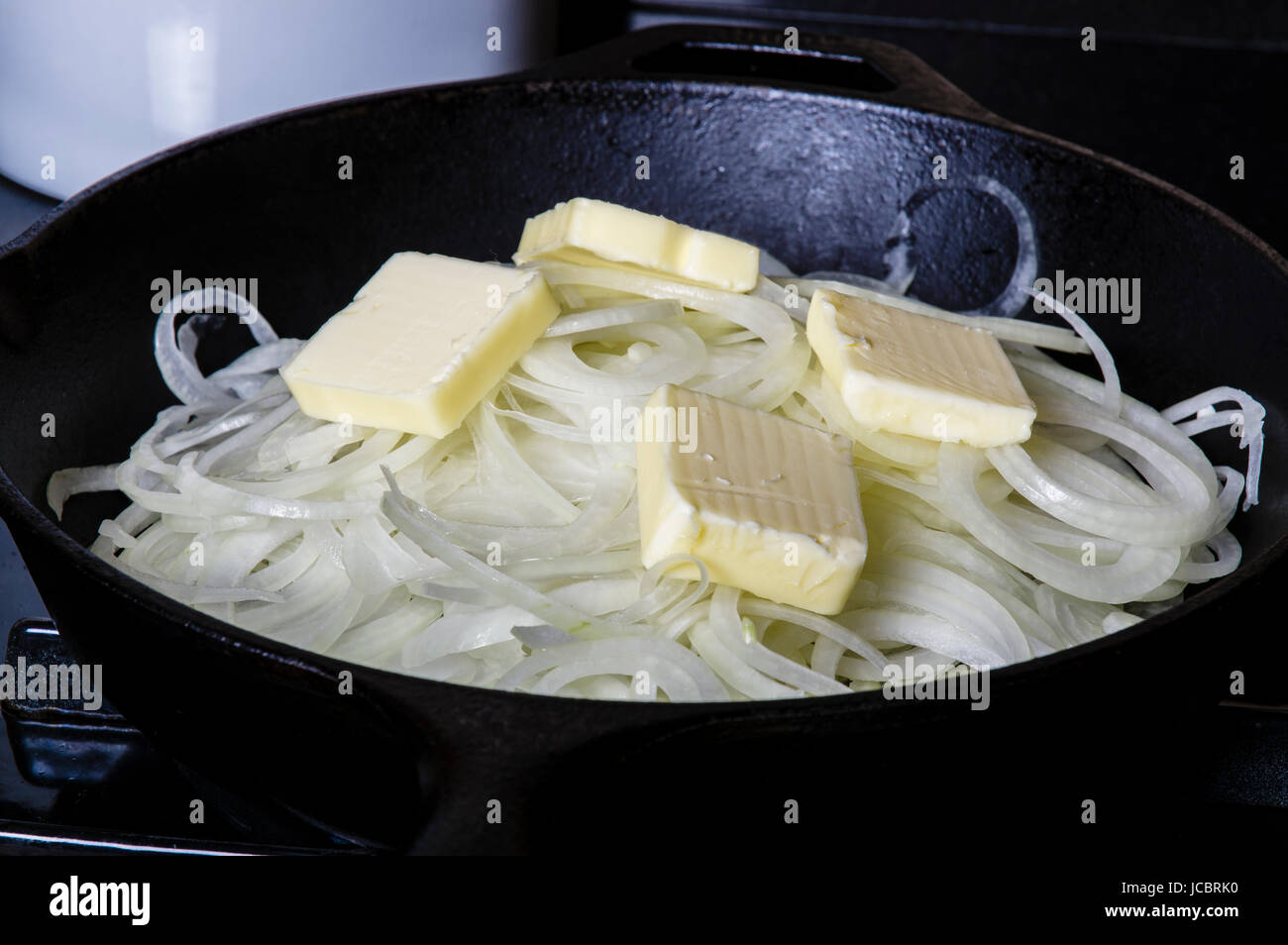 Onions cooking with butter in cast iron skillet Stock Photo Alamy