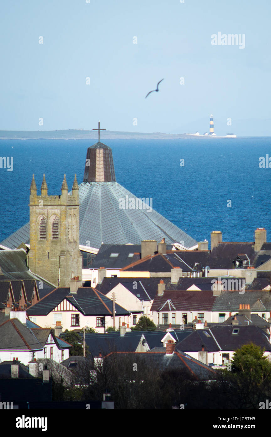 Religious buildings in a town with a lighthouse in the distance Stock Photo