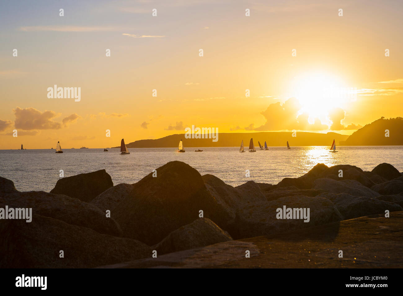 small sailing boats in sea ocean with large sky with willowy clouds