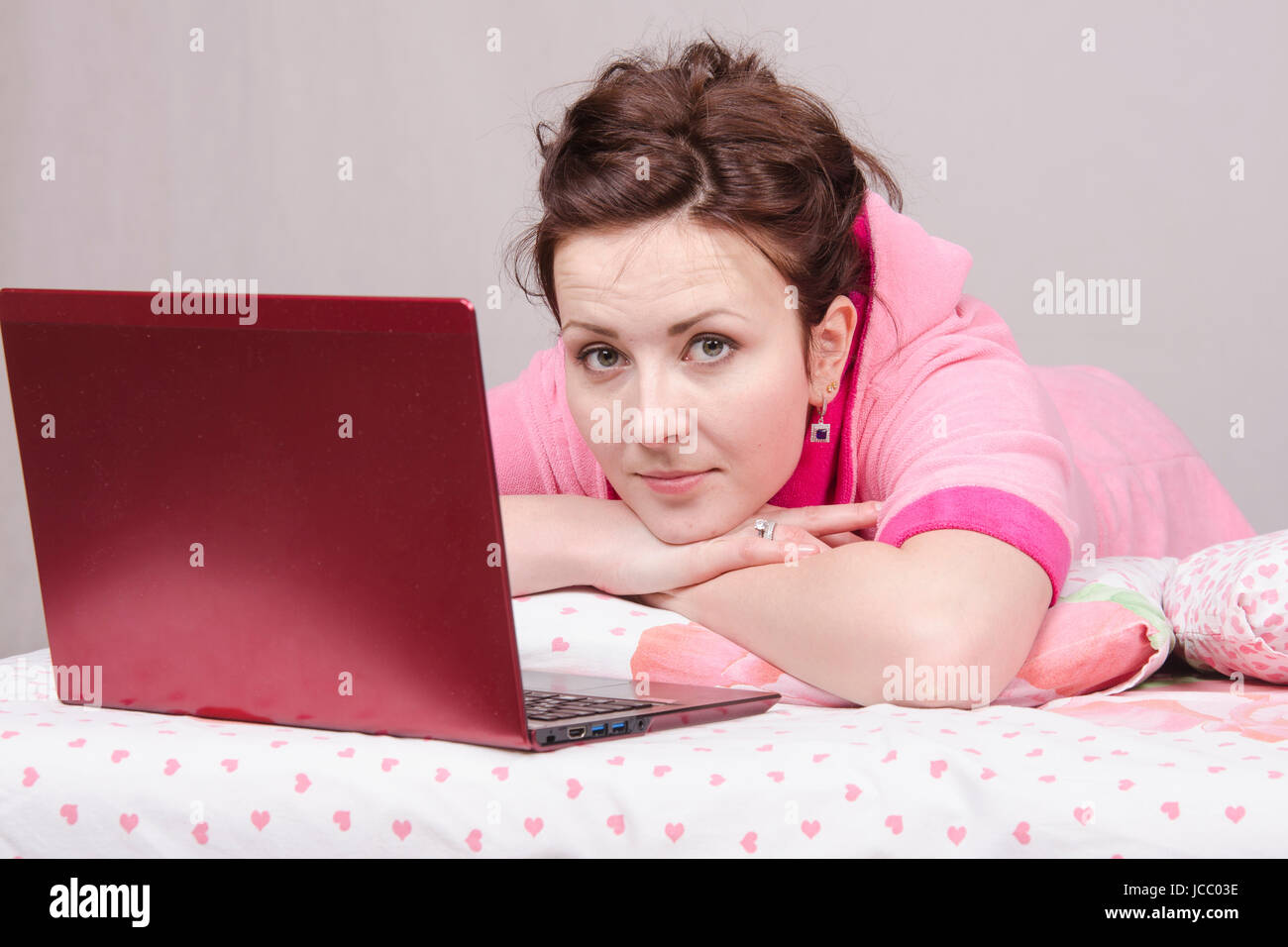 The girl lying in bed and works in the laptop Stock Photo Alamy