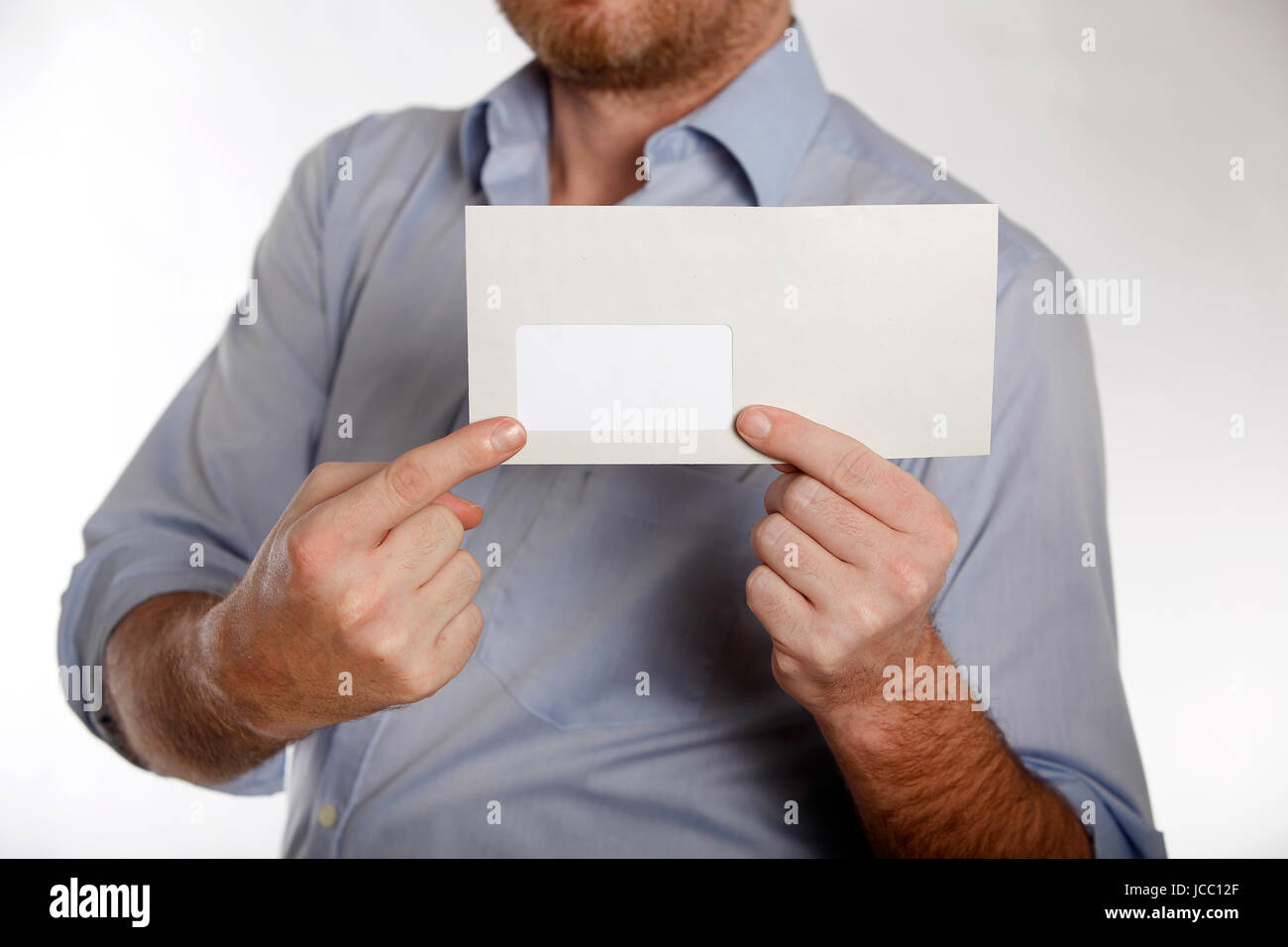 Man in a blue shirt holds a letter into the camera Stock Photo