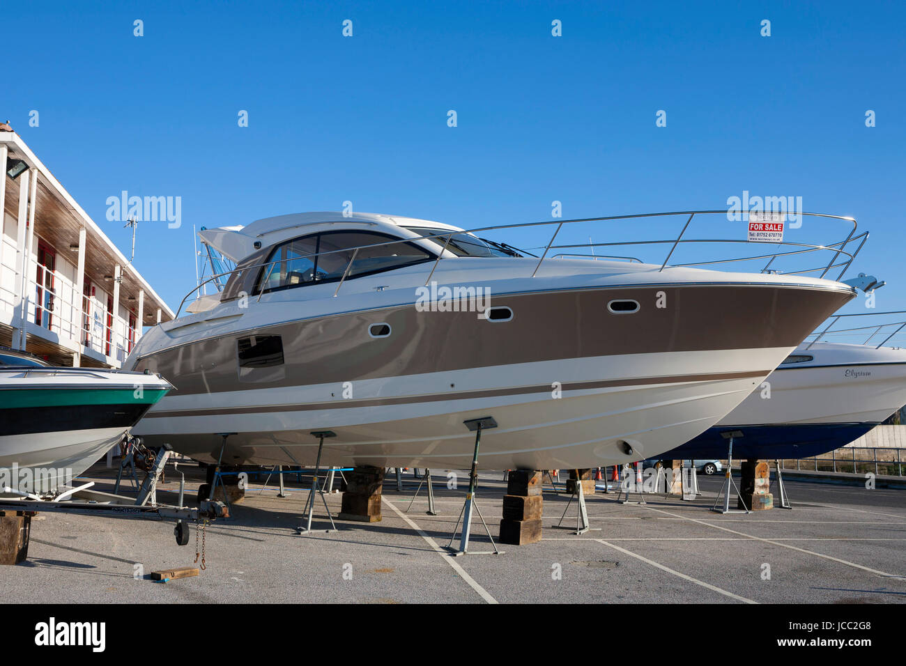 large luxury motor boat yacht in dry dock marina on stilts for sale