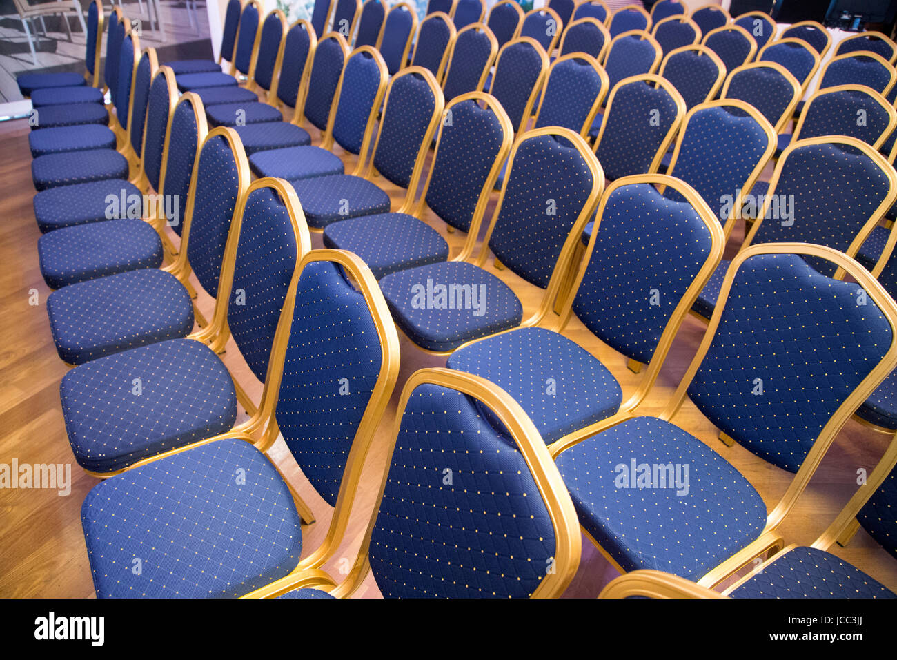 Group of empty the same chairs with modern backrest and green upholstery in rows at unknown auditorium Stock Photo