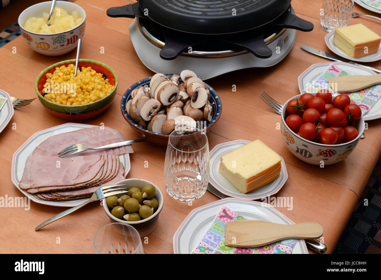 Raclette, tisch, gedeckt, gedeckter tisch, essen, lebensmittel, raclette-grill,  teller, glas, champignonf, schinken, oliven, käse, raclettekäse, raclette-käse  Stock Photo - Alamy