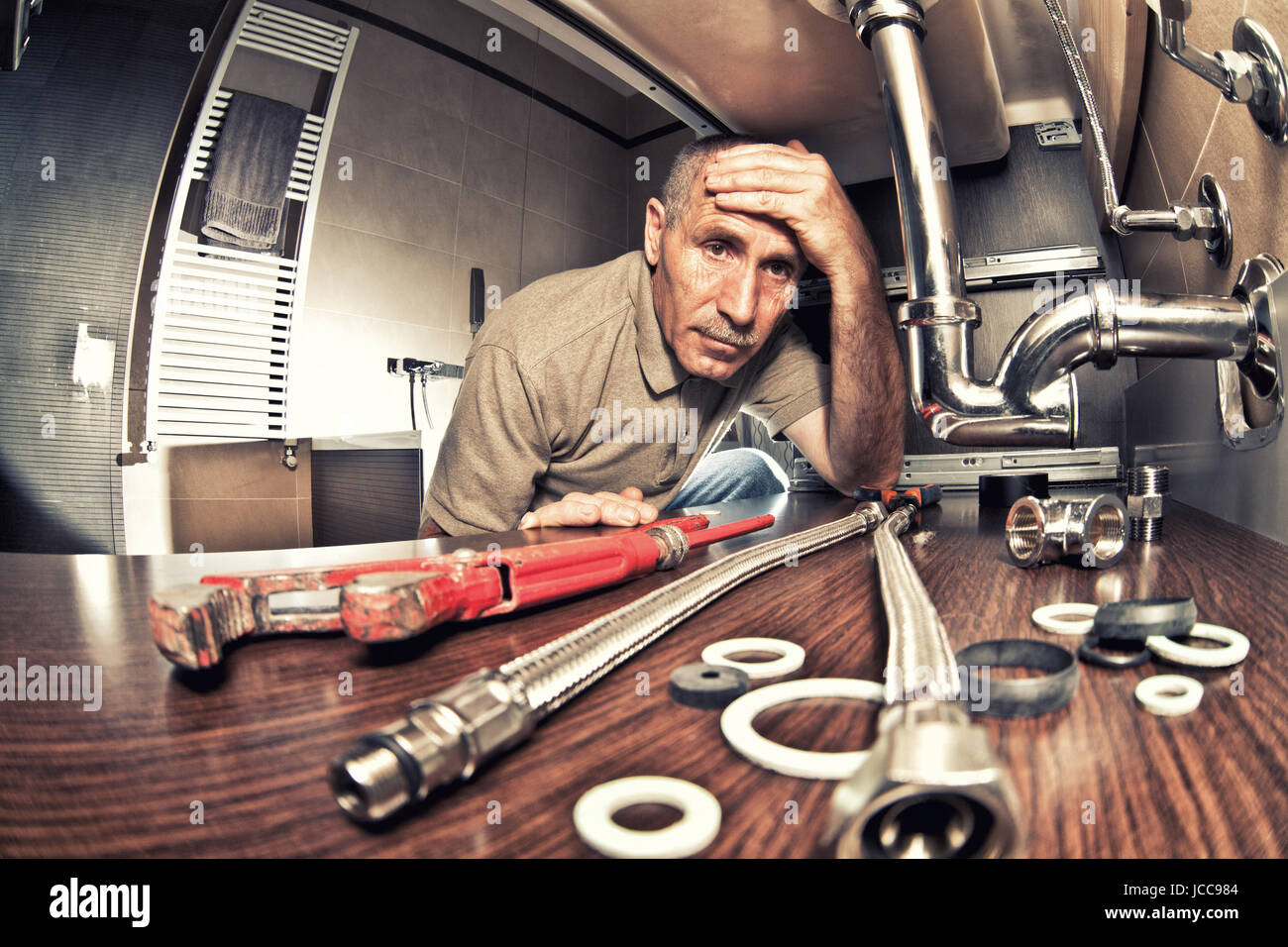 tired an worry plumber at work Stock Photo