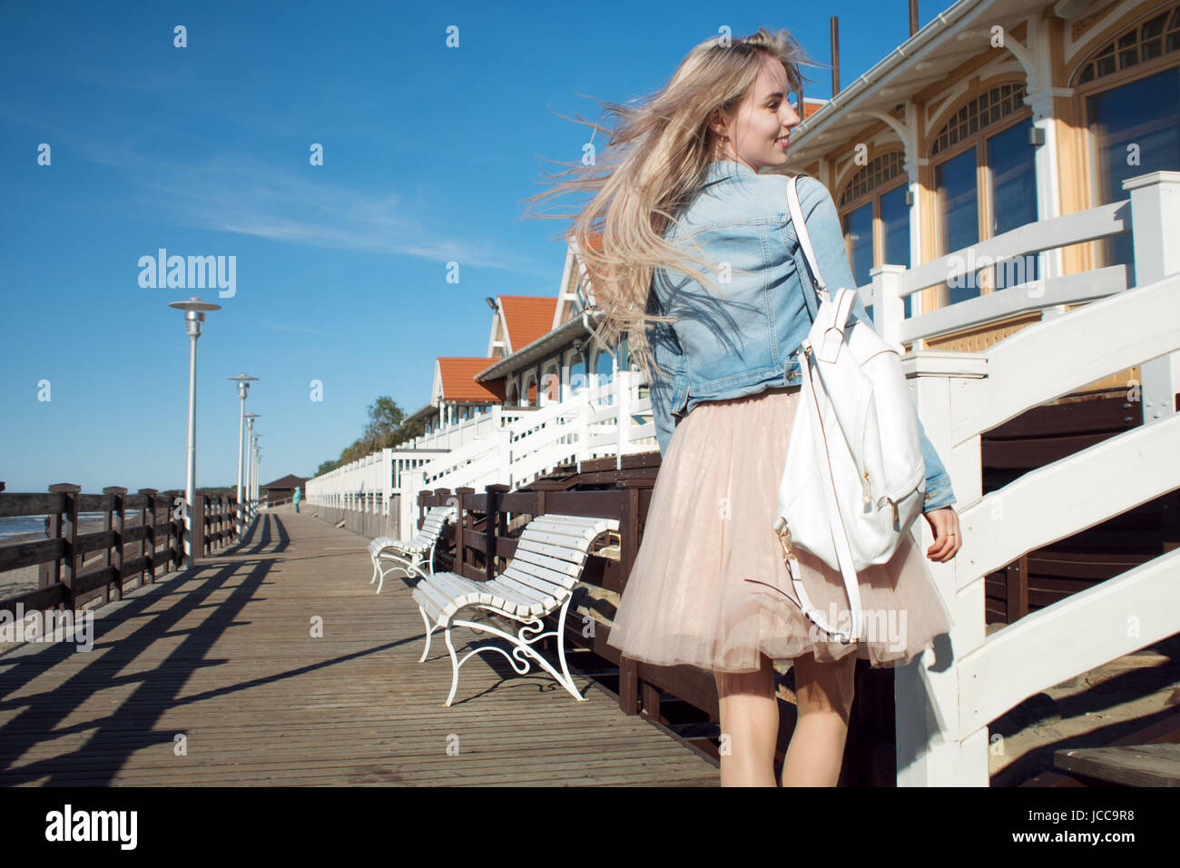 Young cheerful girl on the seashore. Young blonde woman smiling. Stock Photo