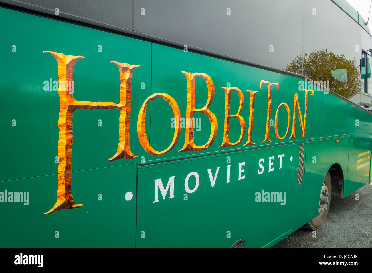 NORTH ISLAND, NEW ZEALAND- MAY 16, 2017: A full bus of tourists with a logo of famous movie, by the entrance to Hobbiton Village at Hobbiton Movie Set Stock Photo