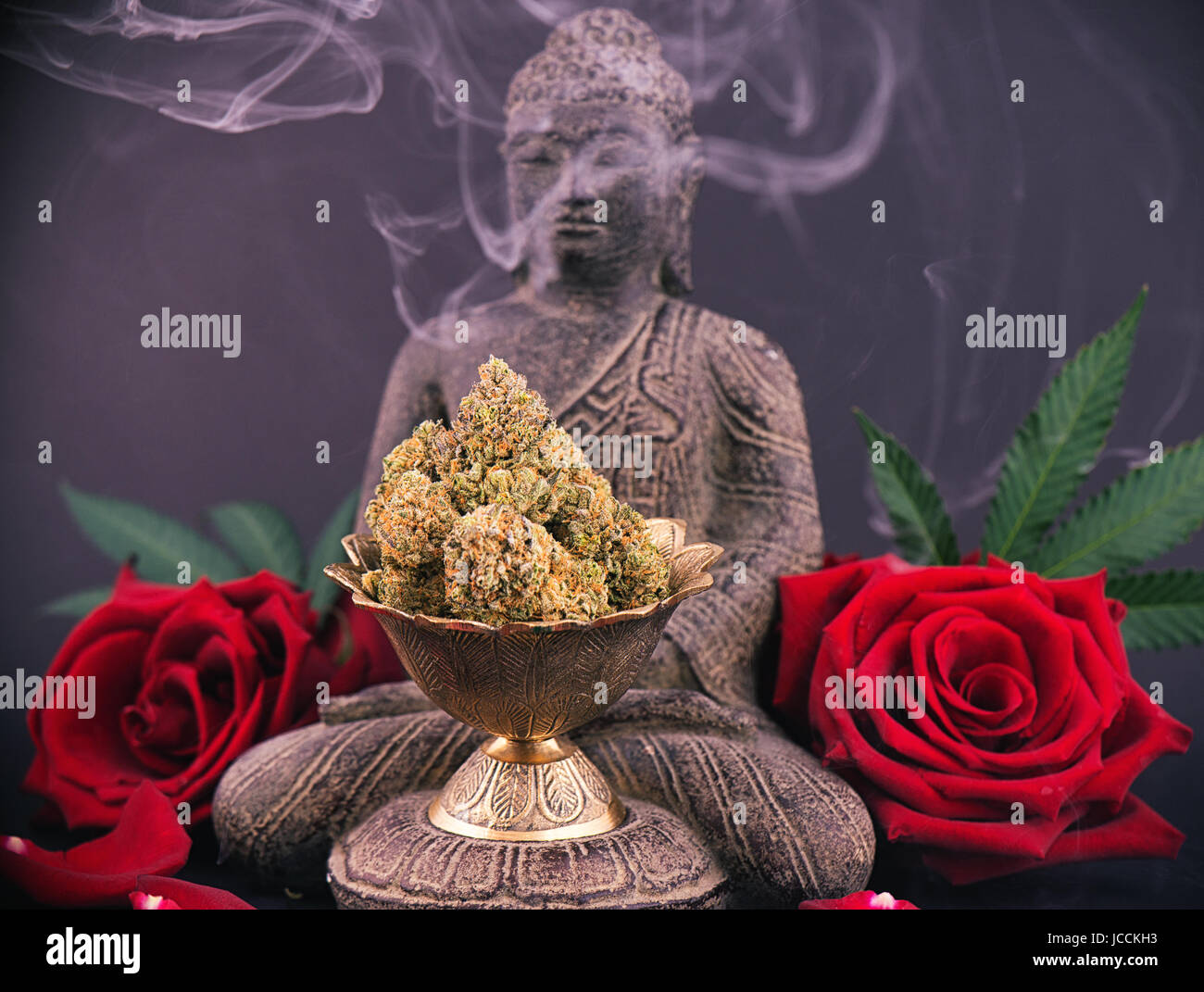 Zen smoky background with buddha statue, red roses and cannabis buds