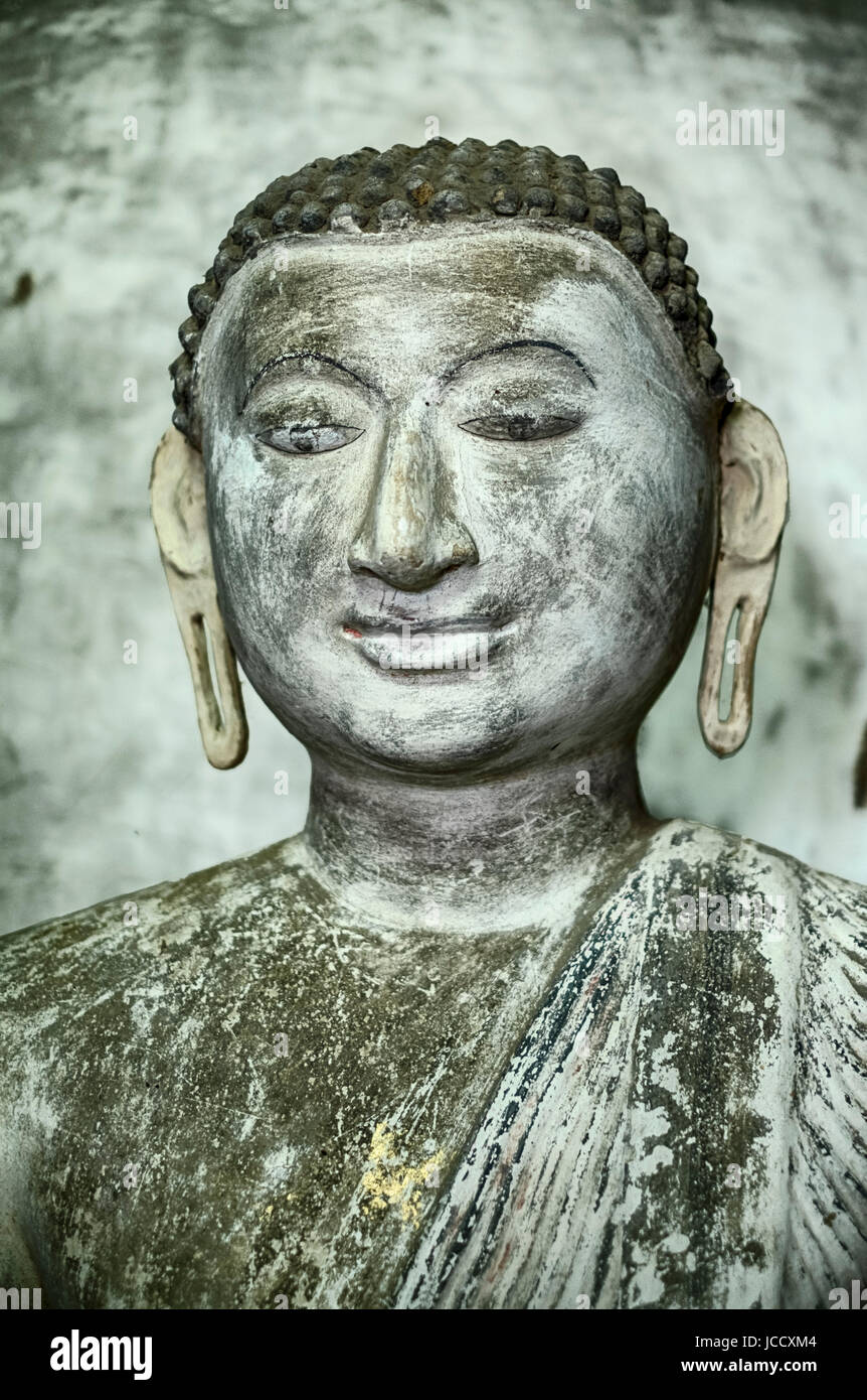 A statue of a young Buddha sits inside one of the caves in the cave