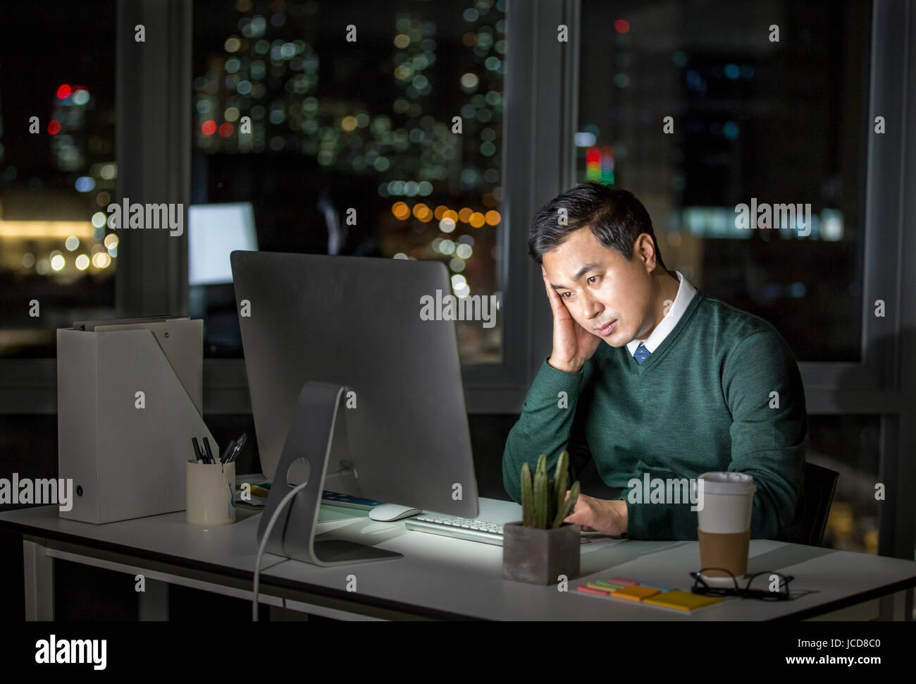 Stressful businessman working overtime at night Stock Photo