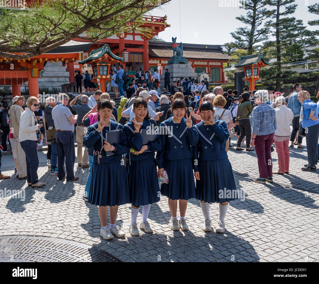 Fushimi Inari Taisha shrine,Schoolgirls posing outside the entrance. Stock Photo