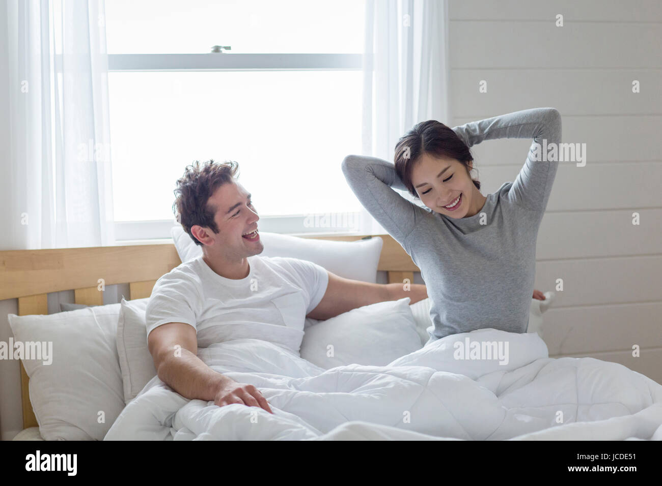 Harmonious multicultural family couple waking up Stock Photo - Alamy