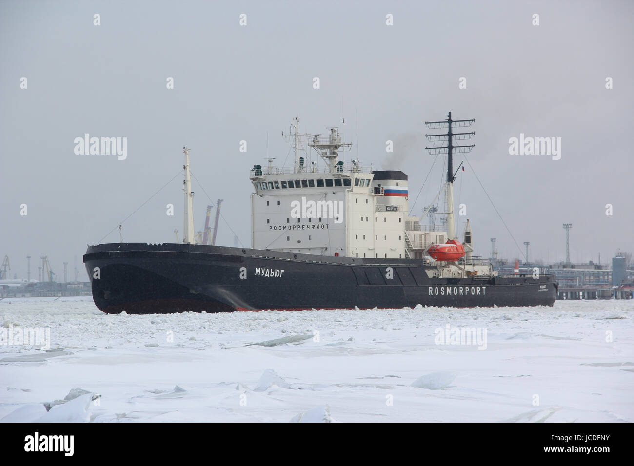 Russian diesel-electric icebreaker 'Mudyug' at the entrance to the port city. It breaks through the ice (clears the way) for merchant ships, liners. Stock Photo