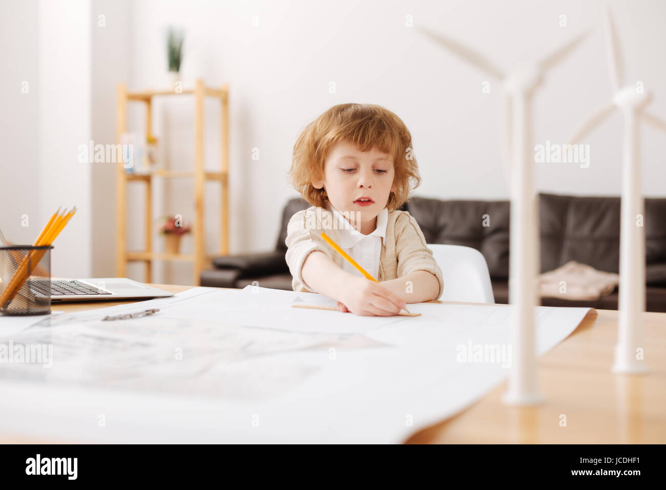 Attentive blonde man-child drawing chart Stock Photo