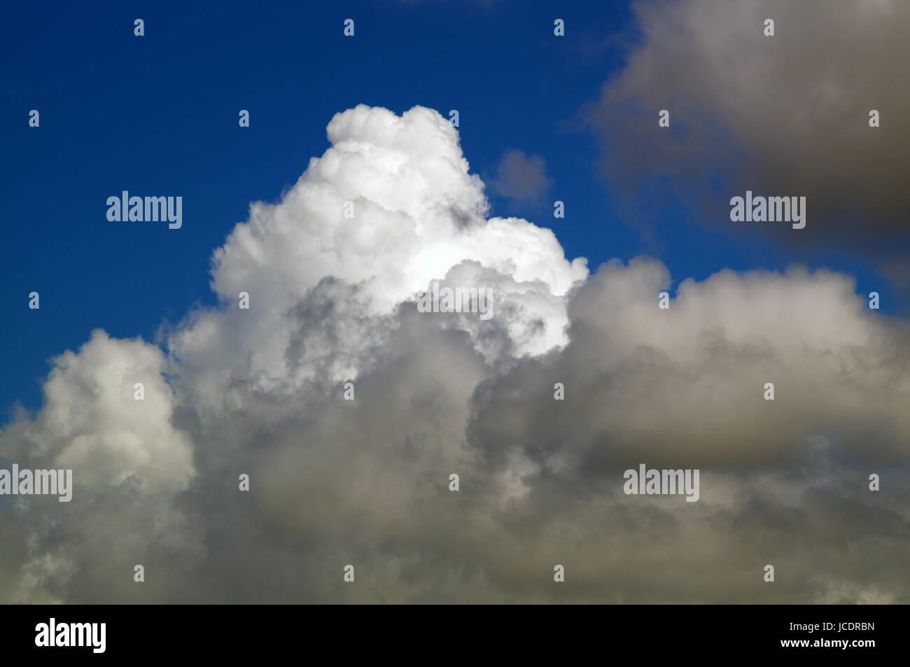 Thick white puffy clouds fill a deep blue sky Stock Photo - Alamy